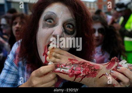 Glastonbury, Somerset, UK. 25 October 2014: Zombie hoards gather at Glastonbury for  annual Zombie walk where participants  dressed as marauding zombies lurch along the high street turning willing victims into the 'undead'  This is the third annual Glastonbury Zombie Walk and is hosted by local charity, Martha Care, with all proceeds going toward supporting families with very sick children. Credit:  Tom Corban/Alamy Live News Stock Photo