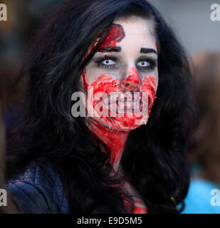 Glastonbury, Somerset, UK. 25 October 2014: Zombie hoards gather at Glastonbury for  annual Zombie walk where participants  dressed as marauding zombies lurch along the high street turning willing victims into the 'undead'  This is the third annual Glastonbury Zombie Walk and is hosted by local charity, Martha Care, with all proceeds going toward supporting families with very sick children. Credit:  Tom Corban/Alamy Live News Stock Photo