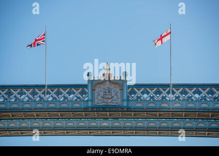 The Union and St George's flags flying on Tower Bridge in London against a clear blue sky Stock Photo