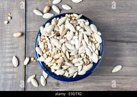 Mixed salted nuts and seeds on a wooden table Stock Photo