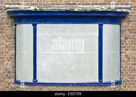 A boarded up window on a building closed down Stock Photo