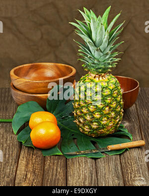 Still Life with Pineapple and Oranges on Wooden background. Closeup. Stock Photo