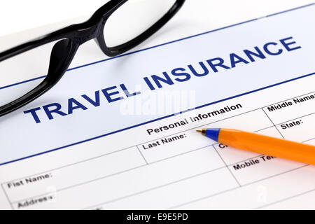 Travel insurance form with glasses and ballpoint pen. Stock Photo