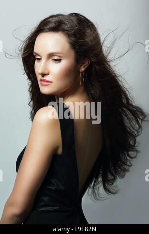 Charm. Aristocratic Lady in Black Dress and Flowing Hair Stock Photo