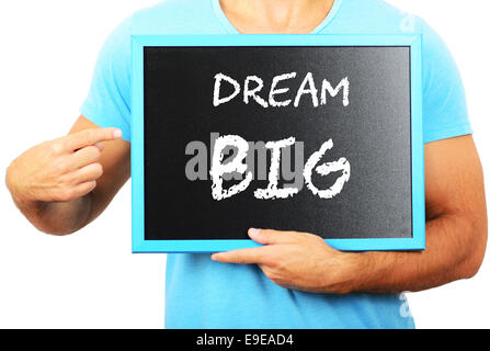 Man holding blackboard in hands and pointing the word DREAM BIG Stock Photo