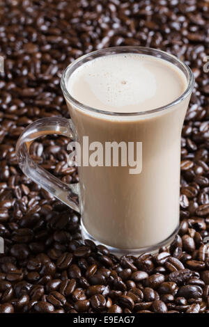 Iced coffee in a glass mug on coffee beans. Stock Photo