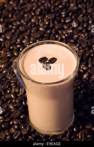 Iced coffee in a glass mug on coffee beans. Stock Photo