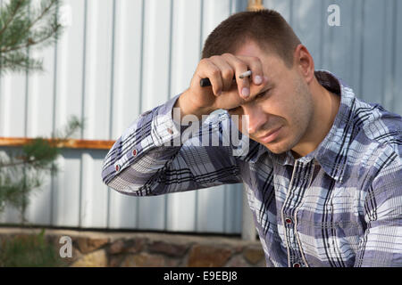 Close up Exhausted Male Building Planner with Hand on the Forehead, Thinking of Something, at the Construction Site Stock Photo