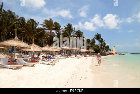 Mauritius beach - People sunbathing with parasols, Belle Mare beach, east coast, Mauritius Stock Photo
