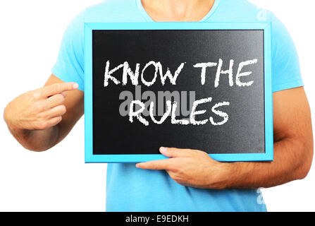 Man holding blackboard in hands and pointing the word KNOW THE RULES Stock Photo