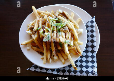 plate of poutine french fries covered in gravy and cheese curds Saskatchewan Canada Stock Photo