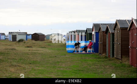 Sitting outside beach huts on Hayling Island sea front Stock Photo
