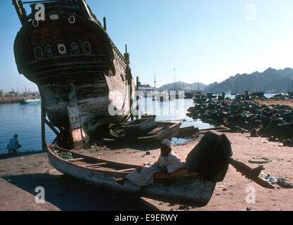 Change in Muttrah, ancient baghala and an outboard motor on a fishing boat, Oman 1975 Stock Photo