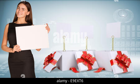 Businesswoman holding empty paper. Open gift boxes with blank labels Stock Photo