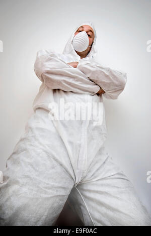 a man dressed in a white paper decorators suit with a dust mask Stock Photo