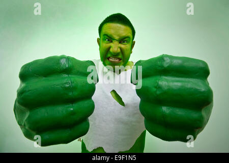 a man dressed in fancy dress comedy costume as the incredible hulk with giant green hands and ripped t shirt Stock Photo