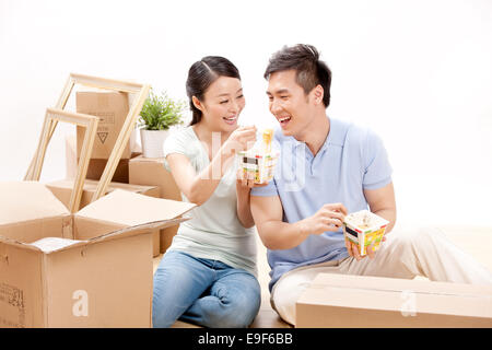 Young couple eating instant noodles Stock Photo