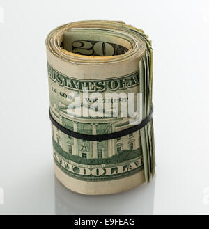 Roll of $20 dollar bills on white table Stock Photo