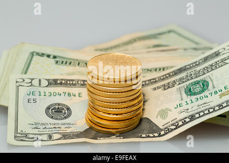 Stack of $20 dollar bills with gold coins Stock Photo