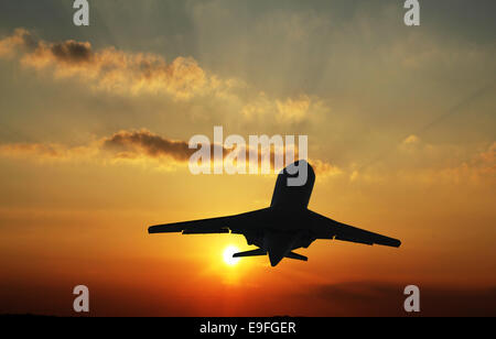 airplane taking off in sunset Stock Photo