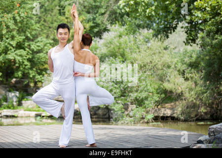 Young couple doing yoga Stock Photo