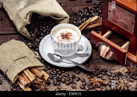 hot cup of coffee and fresh coffee beans and coffee grinder Stock Photo