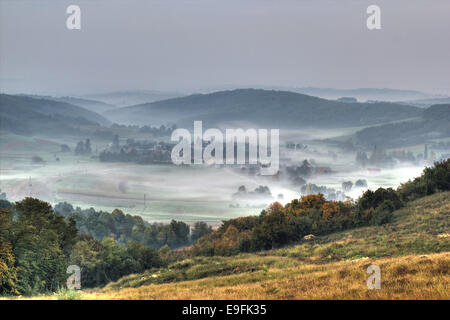 Rural mountain village in fog aerial view Stock Photo
