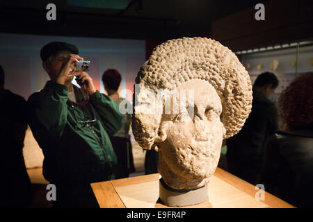 UK, England, Wiltshire, Bath, Roman Baths exhibition, visitor taking photograph of statue fragment Stock Photo