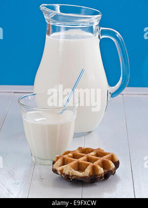 Milk in a jug before blue background Stock Photo
