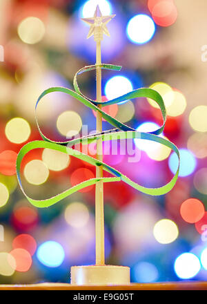 green Christmas tree made from paper on lights background