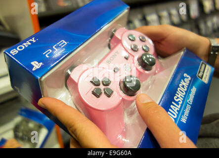 Paphos, Cyprus - December 13, 2013 Pink Sony Dualshock®3 wireless controller for the PlayStation 3 in box in woman hands. Stock Photo