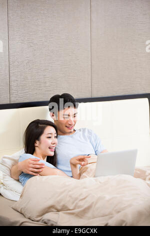 Young couple using digital tablet on bed Stock Photo