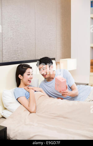 Surprised woman receiving gift from man Stock Photo