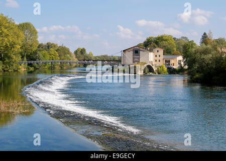 View across Le Doubs river weir to Moulin Ecorces hotel and restaurant by old Roman bridge arch. Dole Jura Franche-Comte France Stock Photo