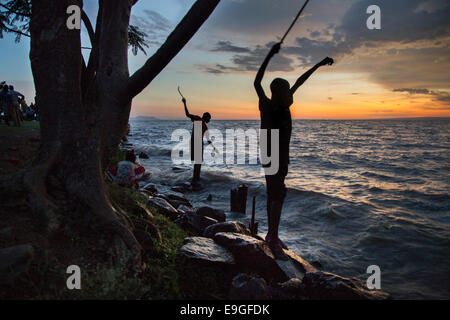 Boys fish off the shores of Lake Victoria in Kisumu, Kenya, East Africa. Stock Photo