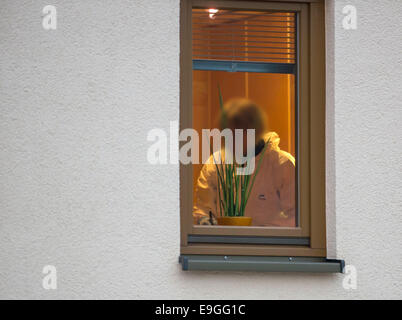 Schwarza, Germany. 27th Oct, 2014. A member of the crime scene investigation unit works in a residential building after three bodies were discovered in Schwarza, Germany, 27 October 2014. The two deceased women (36 and 79) and the 41-year old man lived in the house together. The Criminal Investigation Department investigates whether they were victims of a crime or committed suicide. Photo: Michael Reichel/dpa/Alamy Live News Stock Photo