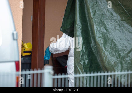 Schwarza, Germany. 27th Oct, 2014. A member of the crime scene investigation unit works in a residential building after three bodies were discovered in Schwarza, Germany, 27 October 2014. The two deceased women (36 and 79) and the 41-year old man lived in the house together. The Criminal Investigation Department investigates whether they were victims of a crime or committed suicide. Photo: Michael Reichel/dpa/Alamy Live News Stock Photo