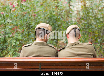 Two Spanish armed forces personnel sitting on park bench. Spain, Europe Stock Photo