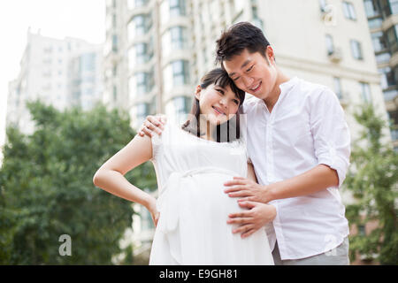 Expectant couple touching baby bump Stock Photo