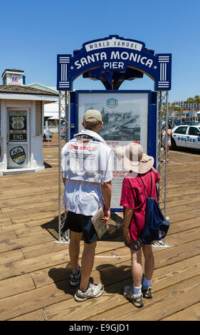 Middle aged couple looking at the information board on Santa Monica Pier, Santa Monica, Los Angeles, California, USA Stock Photo