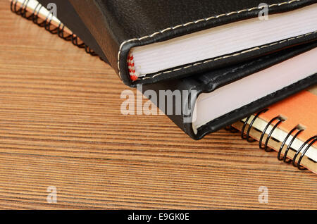 Stack of closed notebooks on a wooden table Stock Photo
