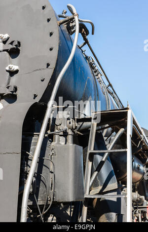 Closeup view of a mechanical equipment around a steam locomotive boiler. Frames, tubes, and cylinders. Stock Photo