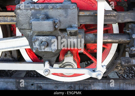 Closeup view of steam locomotive wheels, drives, rods, links and other mechanical details. White, black and red colors Stock Photo