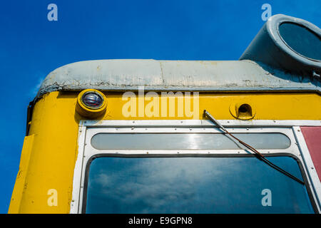 Closeup frontal view of an old diesel locomotive against the background of the clear blue sky Stock Photo