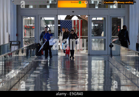 New York, USA. 27th Oct, 2014. Passengers walk in the JKF International Airport in New York, the United States, Oct. 27, 2014. New York State Governor Andrew Cuomo loosened some of the restrictions on people returning to the US from West Africa. Under the new guidelines, if a person arrives and had direct contact with people infected with the Ebola virus but is asymptomatic, they will be transported by private vehicle arranged by the New York State Department of Health or local health department, to their homes where they will be quarantined for 21 days. Credit:  Wang Lei/Xinhua/Alamy Live New Stock Photo