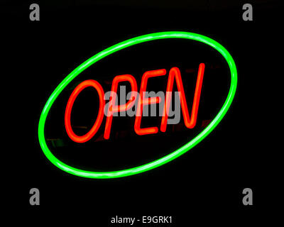 Illuminated neon open sign outside lit up at night on a shop window to advertise that the retail outlet is serving. Stock Photo