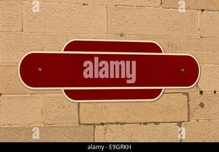 Traditional blank railway sign on the wall of a train station for insertion of your message or place name in middle. Stock Photo