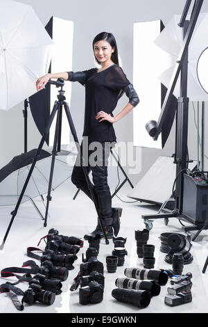 Photographer in studio with many cameras on the ground Stock Photo