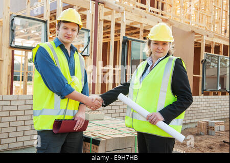 civil engineer and worker shaking hands at the construction site Stock Photo