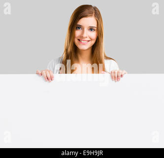 Young and beautiful woman holding a big blank board, isolated over white background Stock Photo